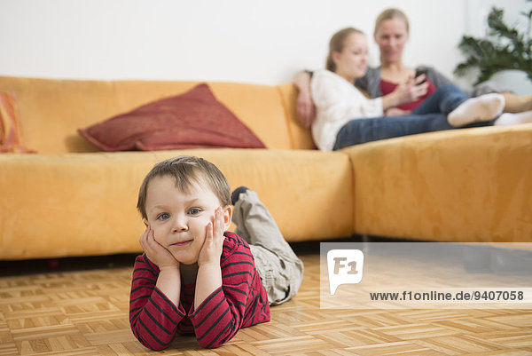 Boy feels bored while mother and sister having chat