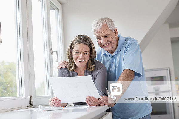 Smiling couple looking at construction plan