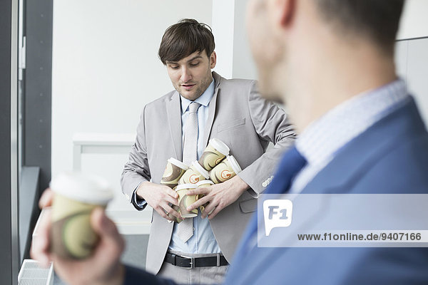 Businessmen holding coffee cups to go for all