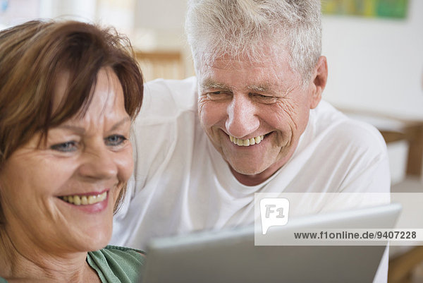 Senior couple using digital tablet  smiling