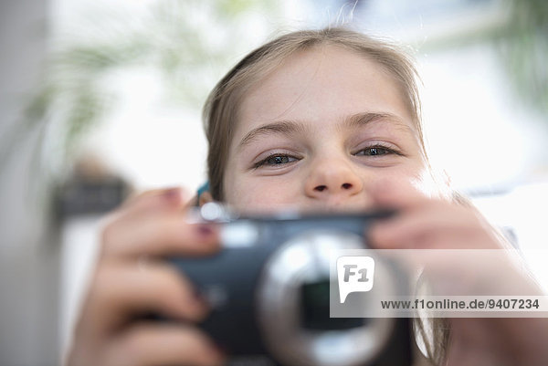 Portrait of girl with camera  smiling
