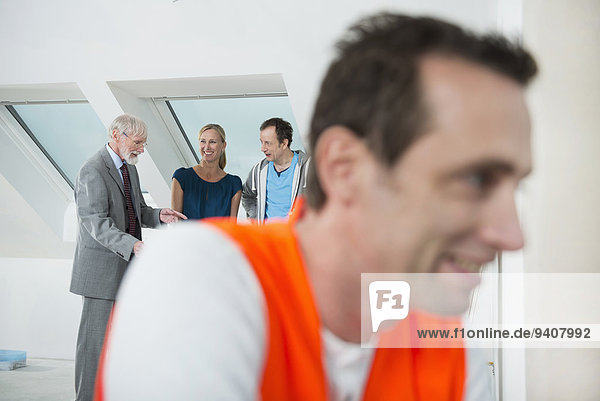 Architect  couple and construction worker at construction site of new building