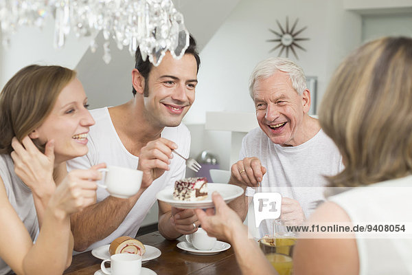 Family with adult children at table eating cake
