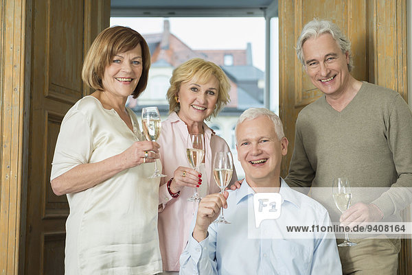 Portrait of friends holding glasses of sparkling wine  smiling