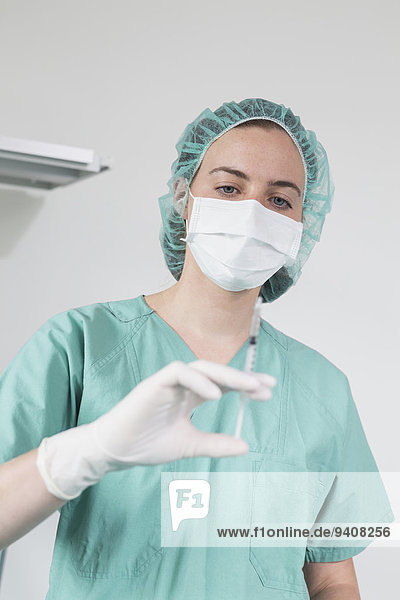 Surgeon in hospital  holding syringe