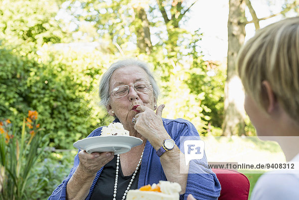 Großmutter Enkelsohn Kuchen essen essend isst Sahne