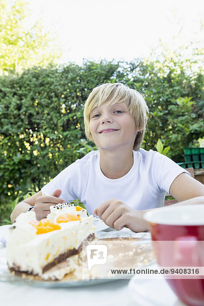 Smiling young boy with cream cake