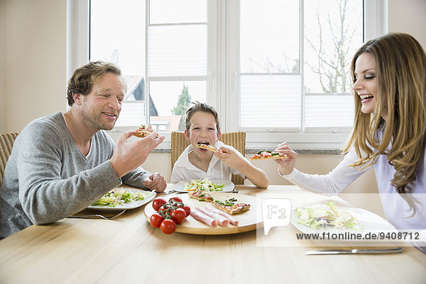Family eating pizza and salad at home