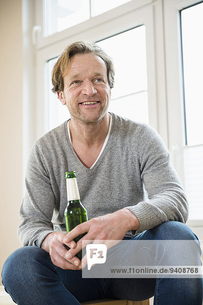 Smiling man holding bottle of beer