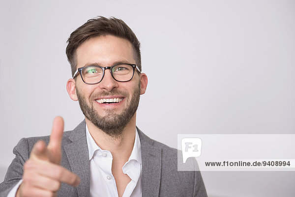Young businessman smiling pointing portrait