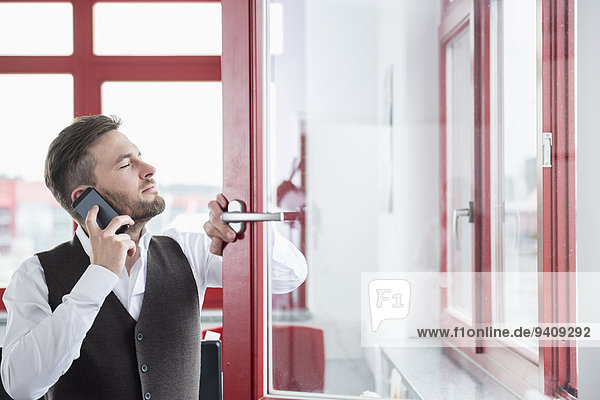 Young man office open window using Smartphone