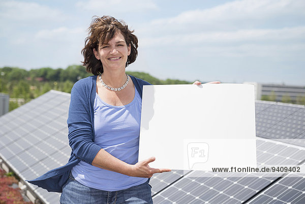 Frau halten Zeichen reifer Erwachsene reife Erwachsene Sonnenkollektor Sonnenenergie Tisch Signal