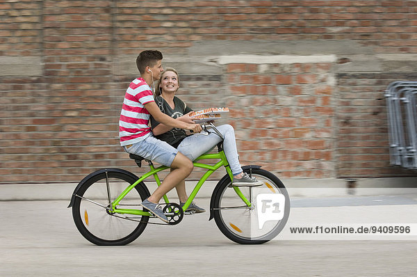 Teenage girl and teenage boy cycling