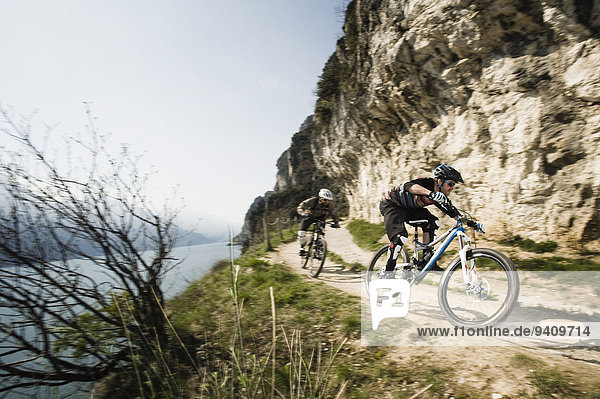 Men riding mountain bike at Lake Garda  Italy