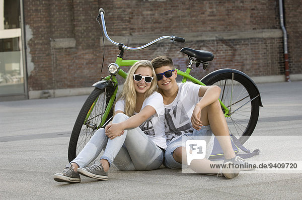 sitzend Jugendlicher lächeln Straße Fahrrad Rad