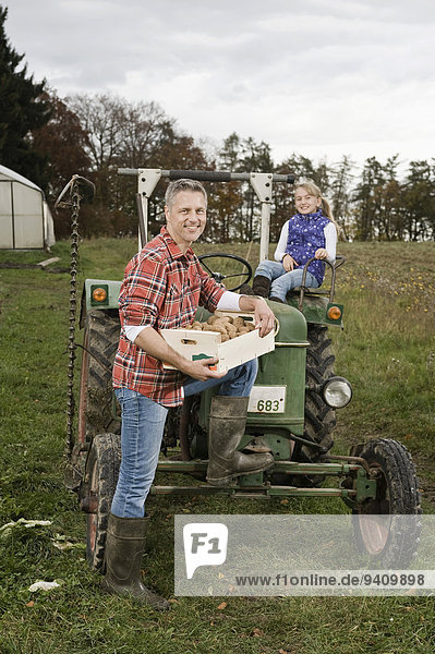Farmer with daughter on tractor