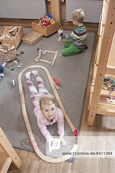 Kindergarten klein Mädchen spielen Holzeisenbahn