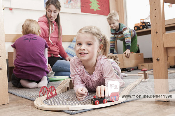 Kindergarten klein Mädchen spielen Holzeisenbahn