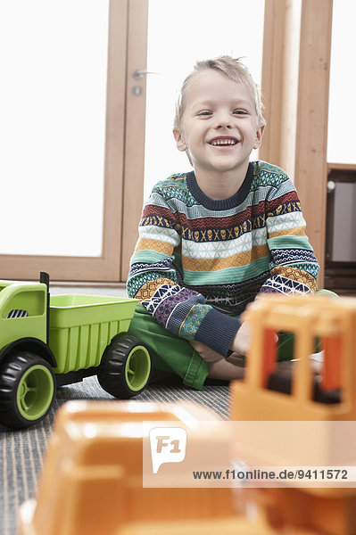sitzend Kindergarten Portrait lächeln Junge - Person klein Boden Fußboden Fußböden