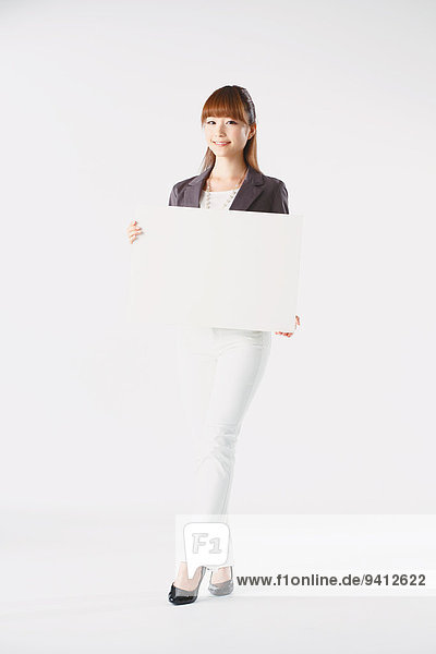 Full length portrait of Japanese young businesswoman against white background