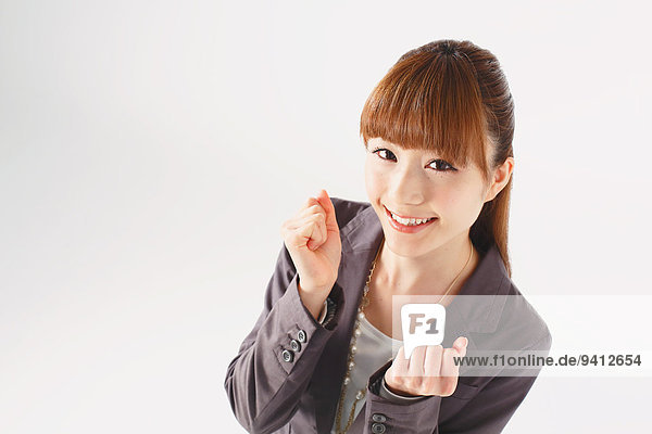 Half length portrait of Japanese young businesswoman against white background