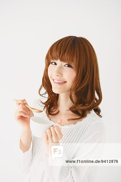 Half length portrait of young Japanese woman against white background