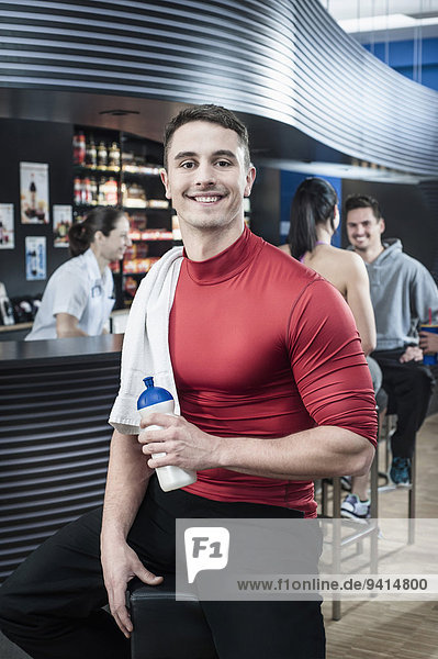 Smiling young man at the bar of a gym