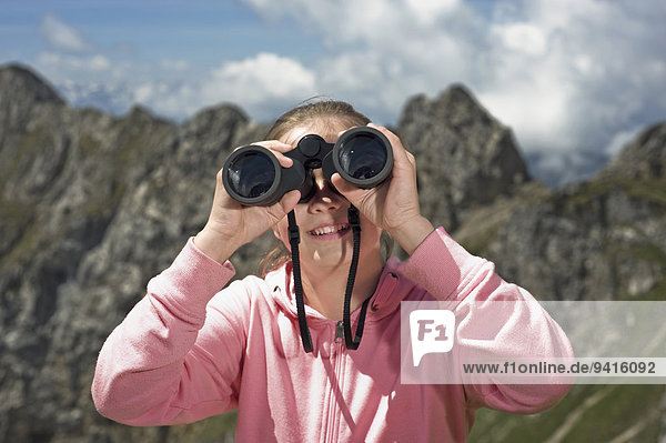 Girl holding binoculars Alps bird watching