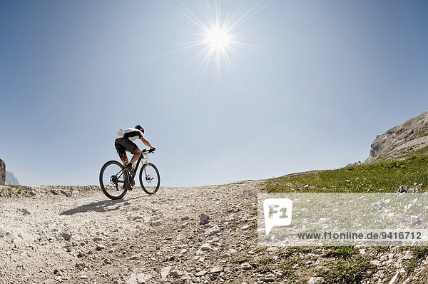 Mountainbiker riding up steep mountain track