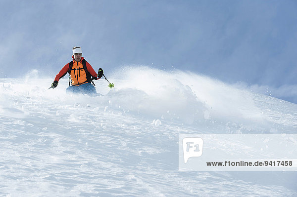Mann Alpen Skisport Pulverschnee Gesichtspuder tief Schnee
