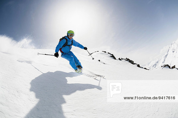 Mann Sonnenstrahl Skifahrer Skisport Hang steil