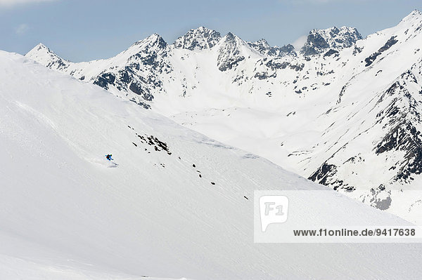 Man skiing downhill steep ski slope Alps