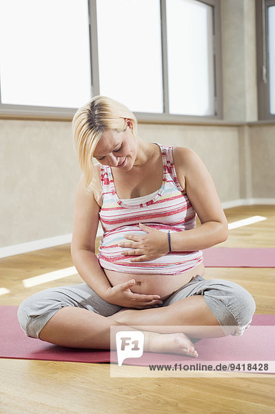 sitzend Frau Boden Fußboden Fußböden Schwangerschaft Yoga Studioaufnahme