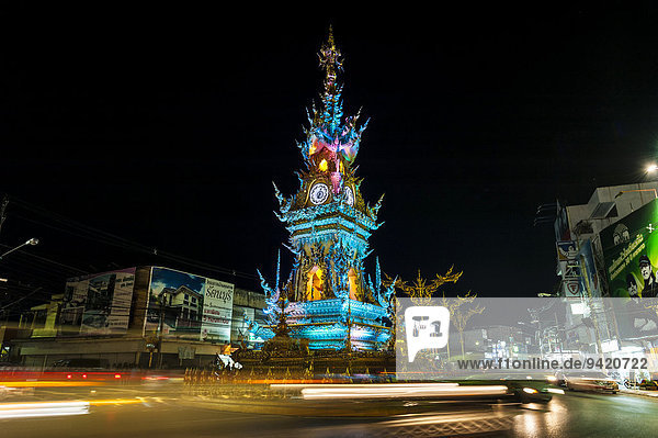 Colourfully illuminated Clock Tower at night with light trails of vehicles Wiang Mueang Chiang Rai Province Chiang Rai Province Northern Thailand Thailand