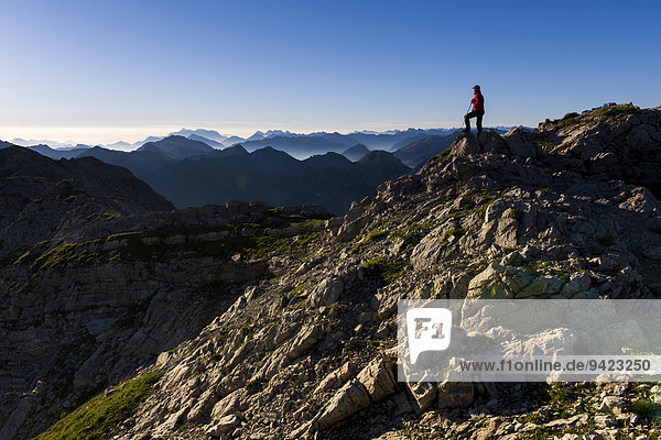Peaks of the Allgäu Alps in the early morning with a hiker  Oberstdorf  Bavaria  Germany