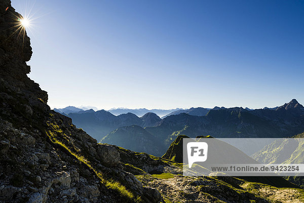Gestaffelte Gipfel der Allgäuer Alpen am frühen Morgen mit Sonnenstern  Oberstdorf  Bayern  Deutschland