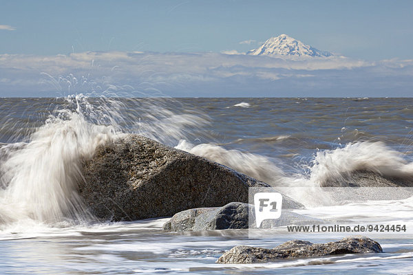 Surf zone on the beach in Kenai on the Kenai Peninsula with Mount Redoubt volcano in the Cook Inlet  Alaska  USA