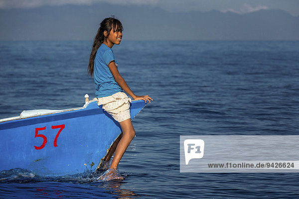 Girl sitting on small fishing boat  Lovina Bay  Bali  Indonesia