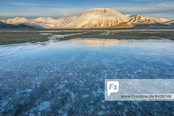 Monte Vettore in the evening light with a frozen puddle with air bubbles  Monti Sibillini National Park  Umbria  Italy