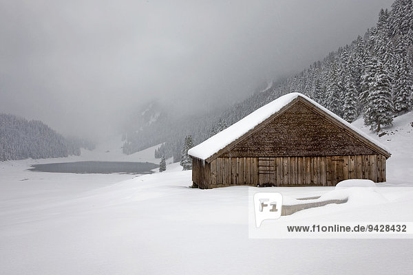 Berghütte im Winterkleid  hinten der Sämtisersee im Alpstein  Ostschweiz  Schweiz  Europa