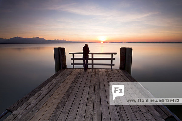 Woman on a dock in the evening light near Chieming on Lake Chiemsee  Bavaria  Germany  Europe  PublicGround