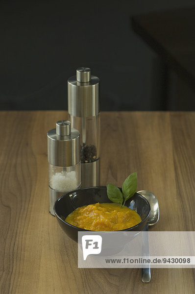 Kürbissuppe mit Basilikum  Salz und Pfeffermühle