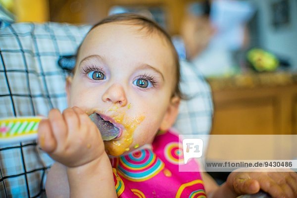 Portrait of baby girl eating from spoon