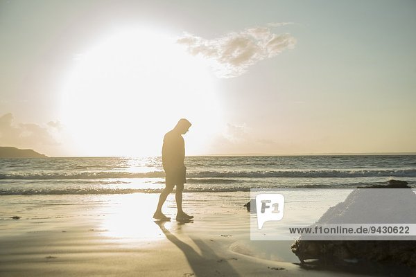 Erwachsener Mann  Spaziergang am Strand  entlang der Küste
