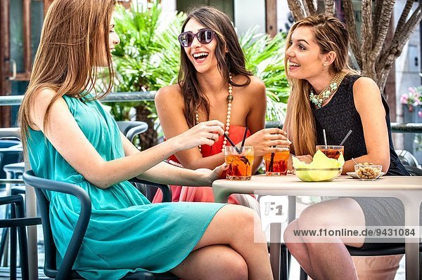 Drei junge modische Freundinnen beim Cocktail im Straßencafé  Cagliari  Sardinien  Italien