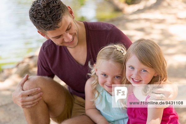 Porträt von Vater und zwei Töchtern am Flussufer