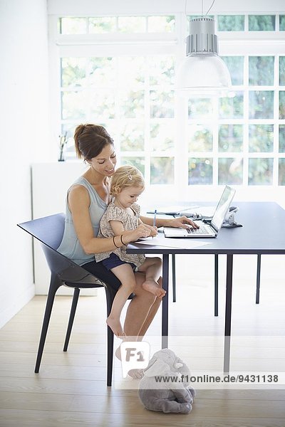 Mid Erwachsene Frau und Kleinkind Tochter Tippen auf dem Laptop
