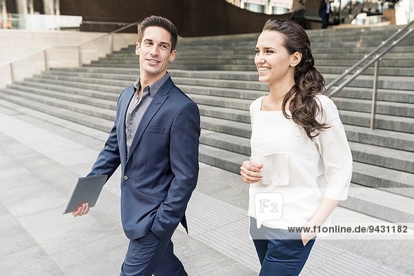 Young businessman and woman chatting whilst walking  London  UK