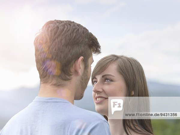 Young couple face to face under bright sunny sky