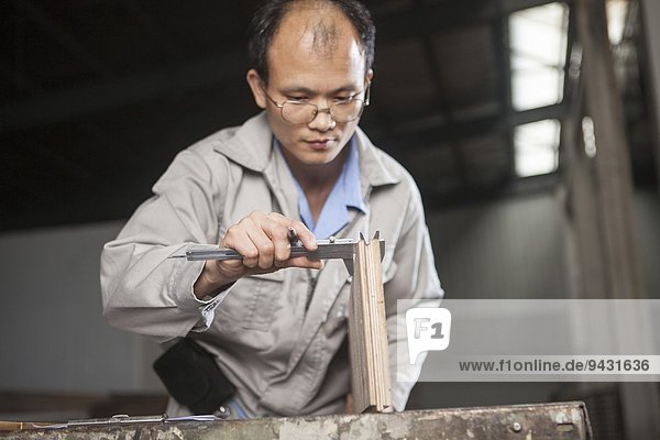 Schreiner messende Holzbohle mit Messschieber in der Fabrik  Jiangsu  China